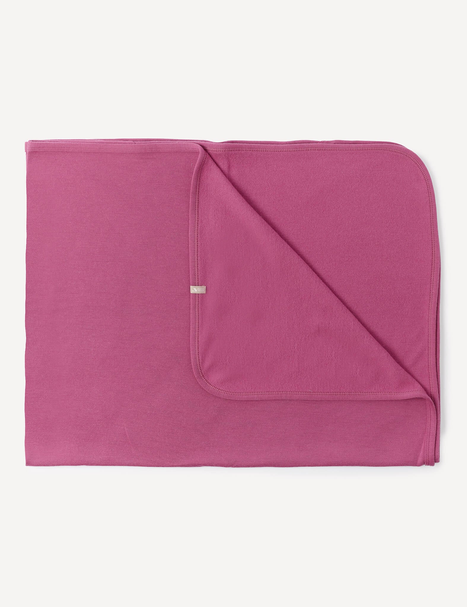 A folded Blanket – Merino Baby AirWool in Hawthorn Rose with rounded edges, displaying both the front and back sides, lying flat on a white background.