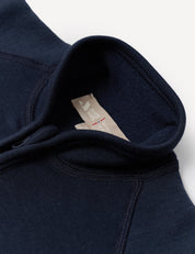 Close-up of the Jacket – Merino Baby AirWool in navy blue, showcasing the zip collar with visible stitching and a beige MADE IN JAPAN tag inside the neck area, featuring breathable insulation.