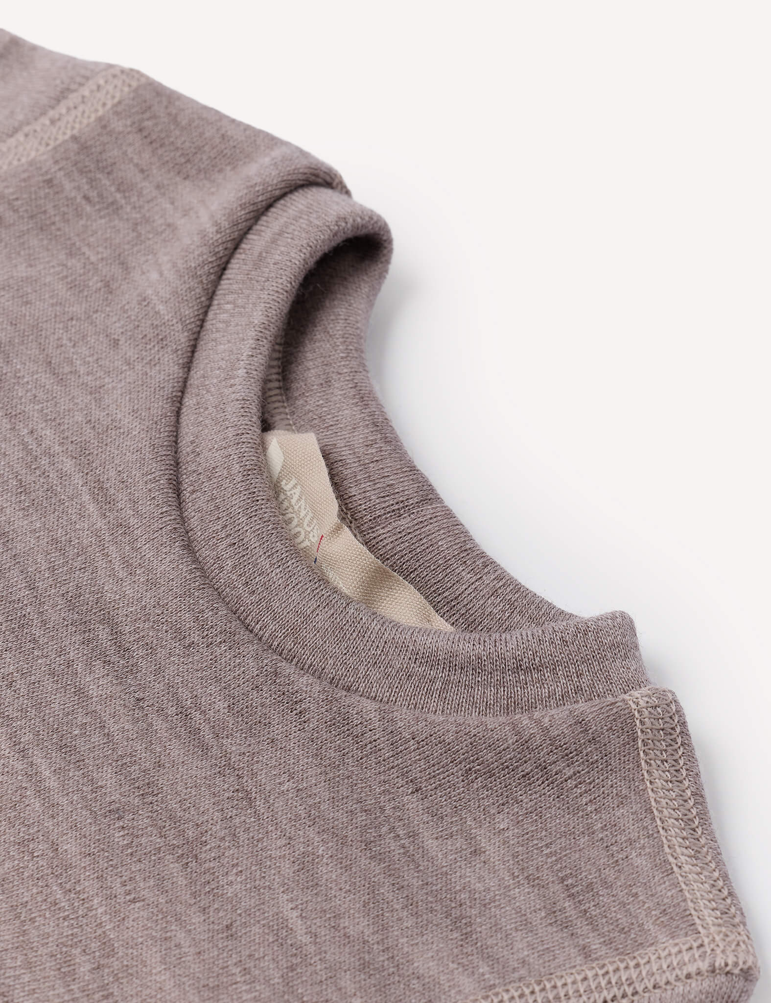 Close-up of the Body – Merino Baby AirWool shirt collar in mauve or taupe, highlighting the distinctive AirWool knit stitching and a portion of the inner label against a white background.