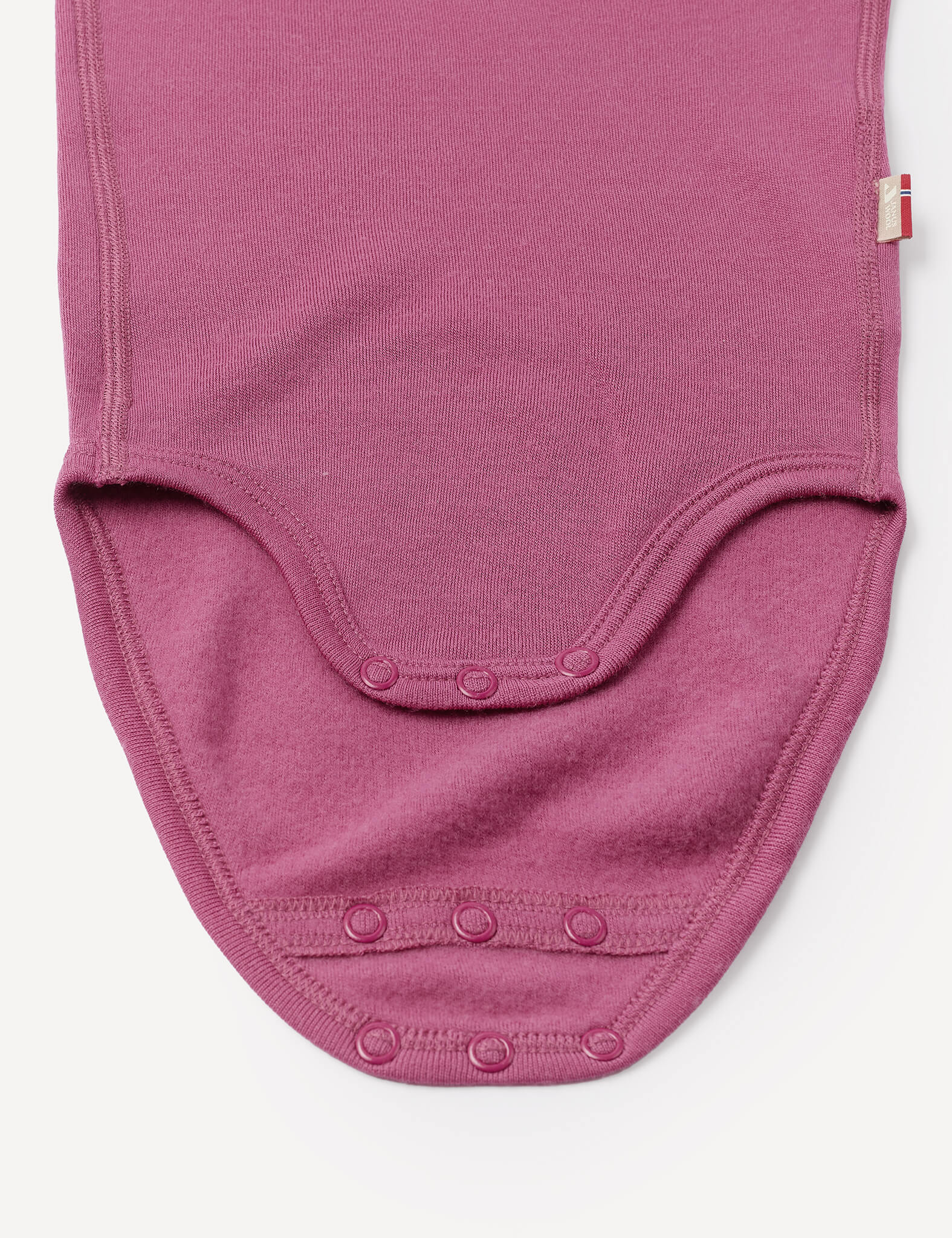 Close-up of the Body – Merino Baby AirWool in mauve on a white background, highlighting the snap buttons, bottom section, and detailed stitching for breathable comfort.