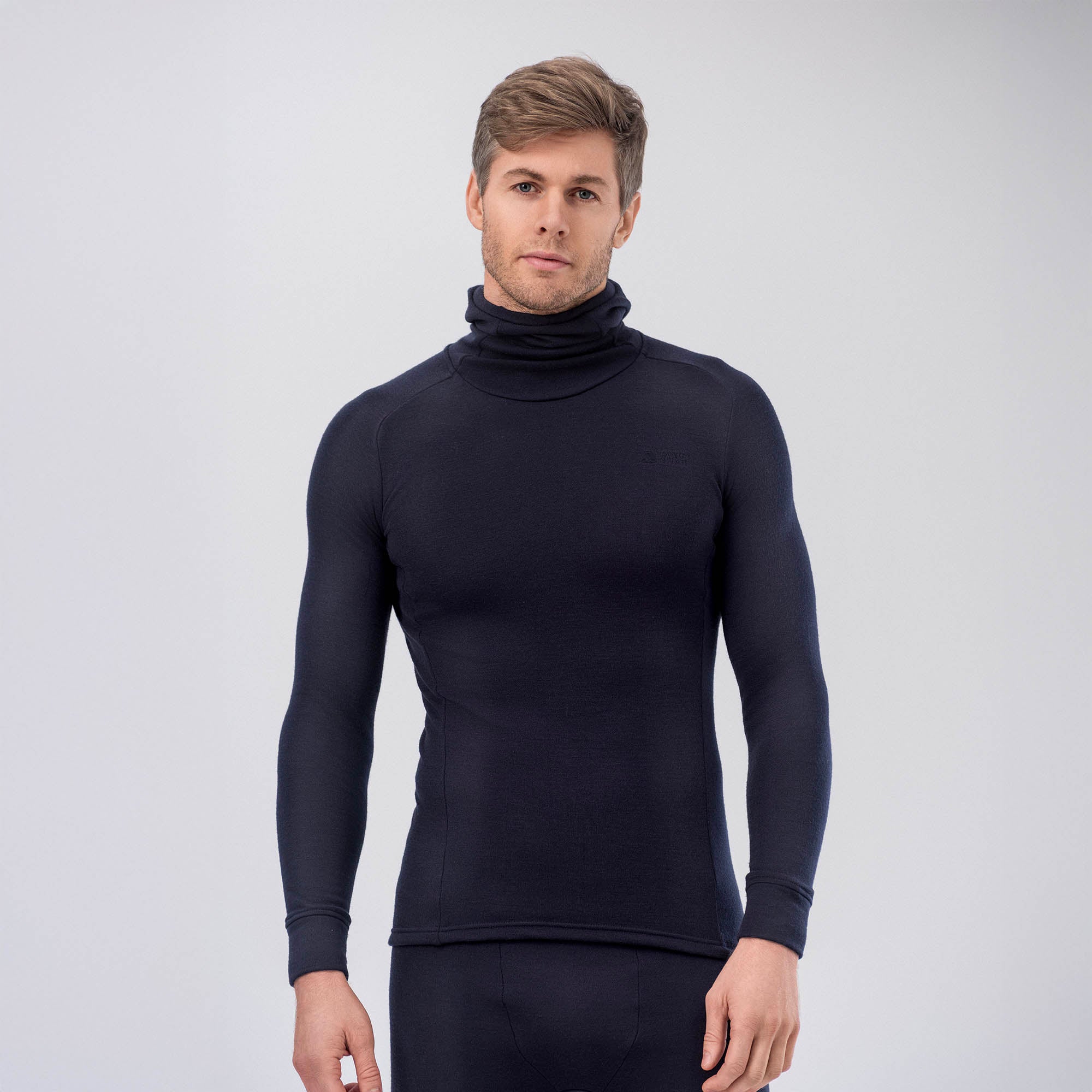 A man with short light brown hair wears a fitted, long-sleeve AirWool 260 Men Hooded Jersey Merino in navy, standing against a plain light gray background.