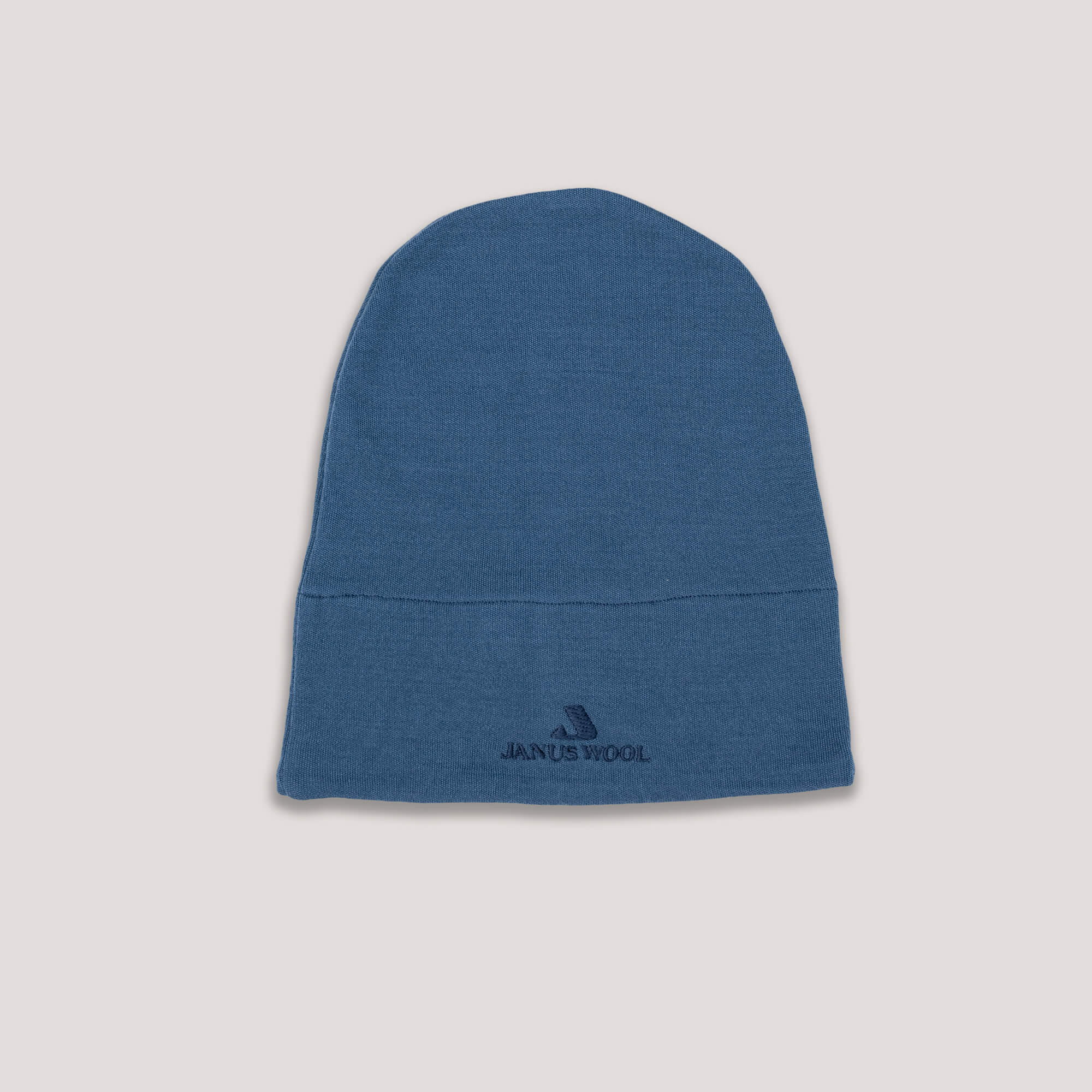 Blue Janus AirWool beanie with logo on a light gray background