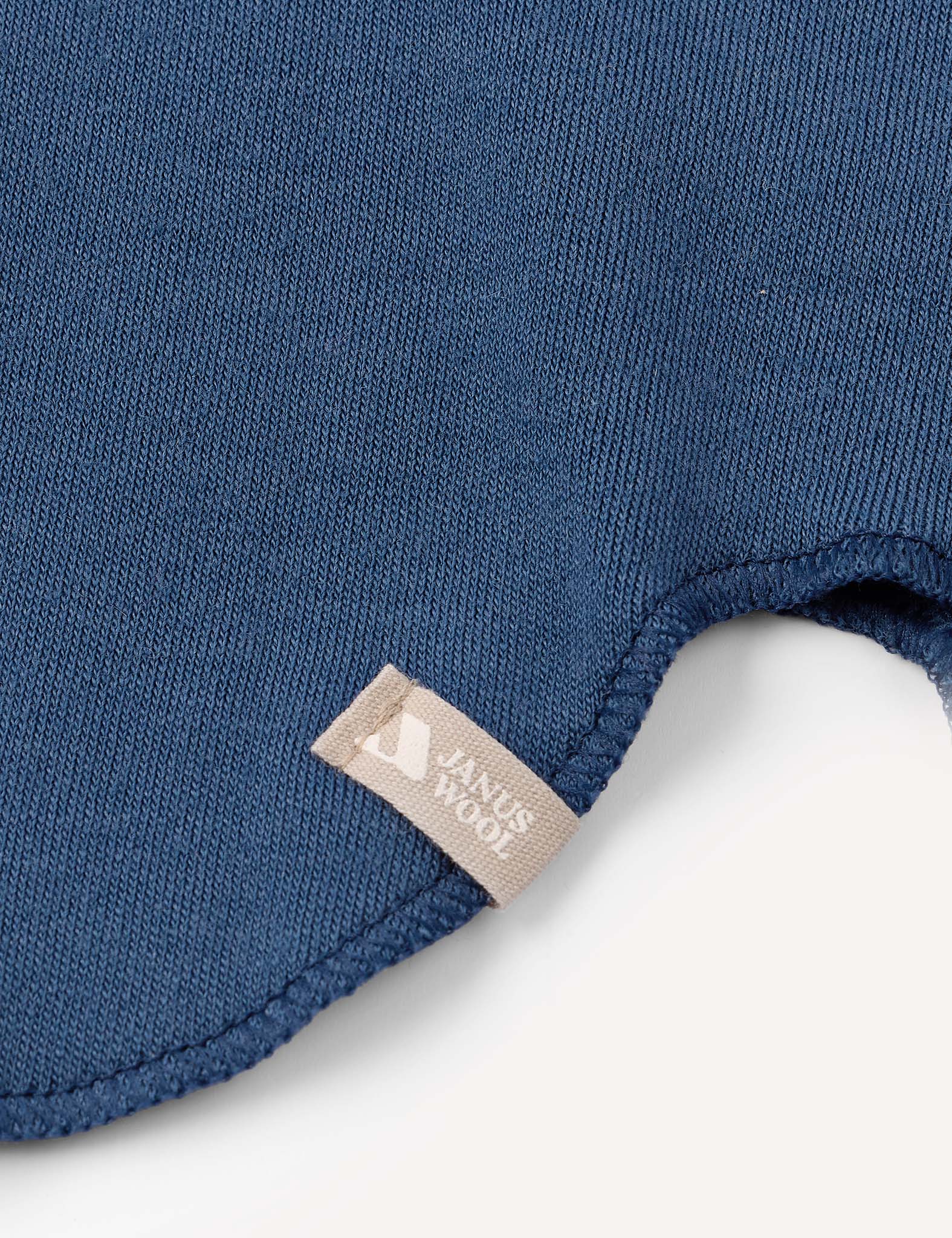 Close-up of a blue ribbed fabric from the Balaclava – Merino Kids AirWool collection, featuring a beige tag. The edge of this warm balaclava is shown with visible stitching detail against a white background.
