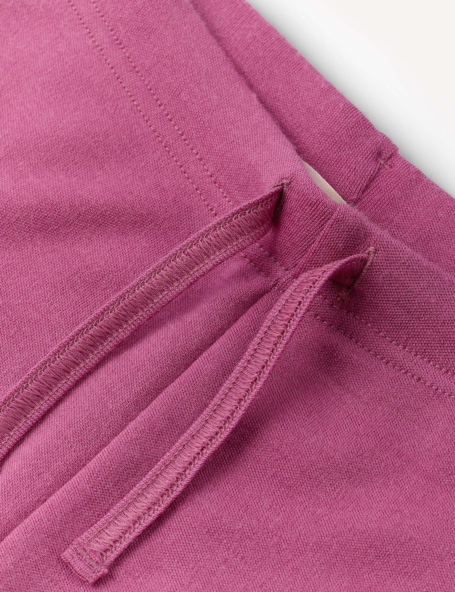 Close-up of the Flarepants – Merino Kids AirWool in a mauve or pinkish-purple shade, featuring a waistband with a matching drawstring and stitched seam detailing. The warm and comfortable material appears to be crafted from brushed AirWool.