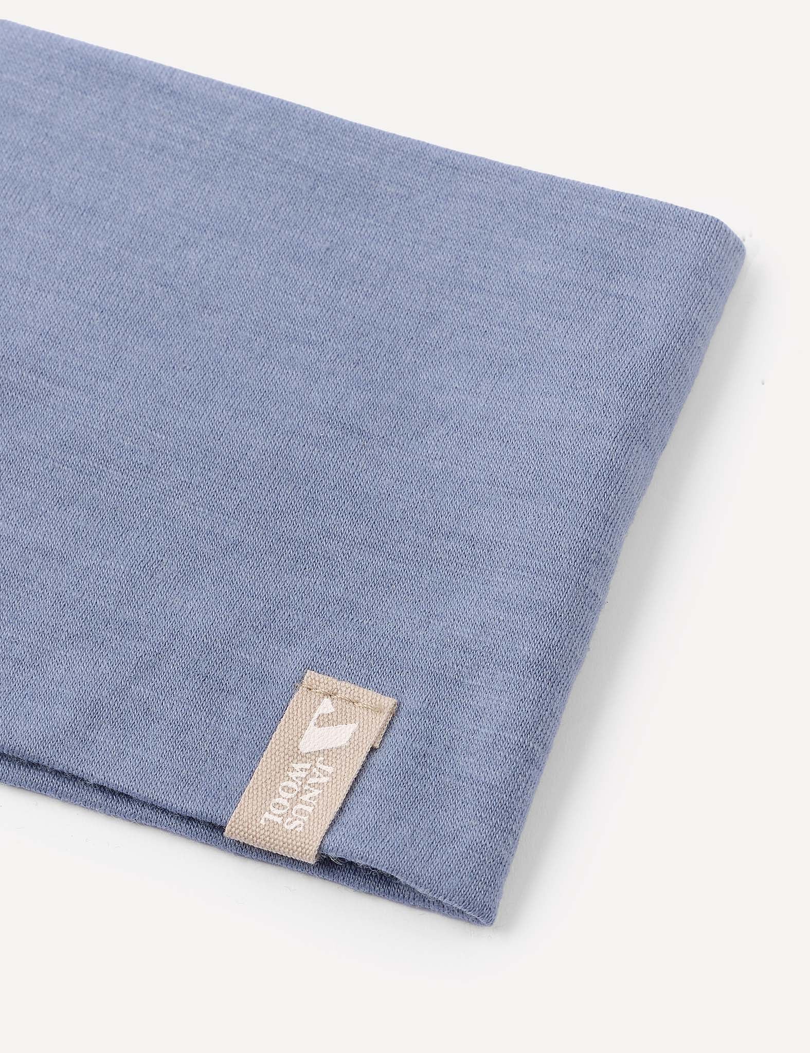 A folded blue Headband – Merino Kids Light with a beige tag reading “FORSAKING” in white text, displayed on a plain white background—ideal for everyday wear or as inspiration for versatile headband designs.