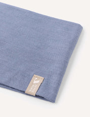 A folded blue Headband – Merino Kids Light with a beige tag reading “FORSAKING” in white text, displayed on a plain white background—ideal for everyday wear or as inspiration for versatile headband designs.