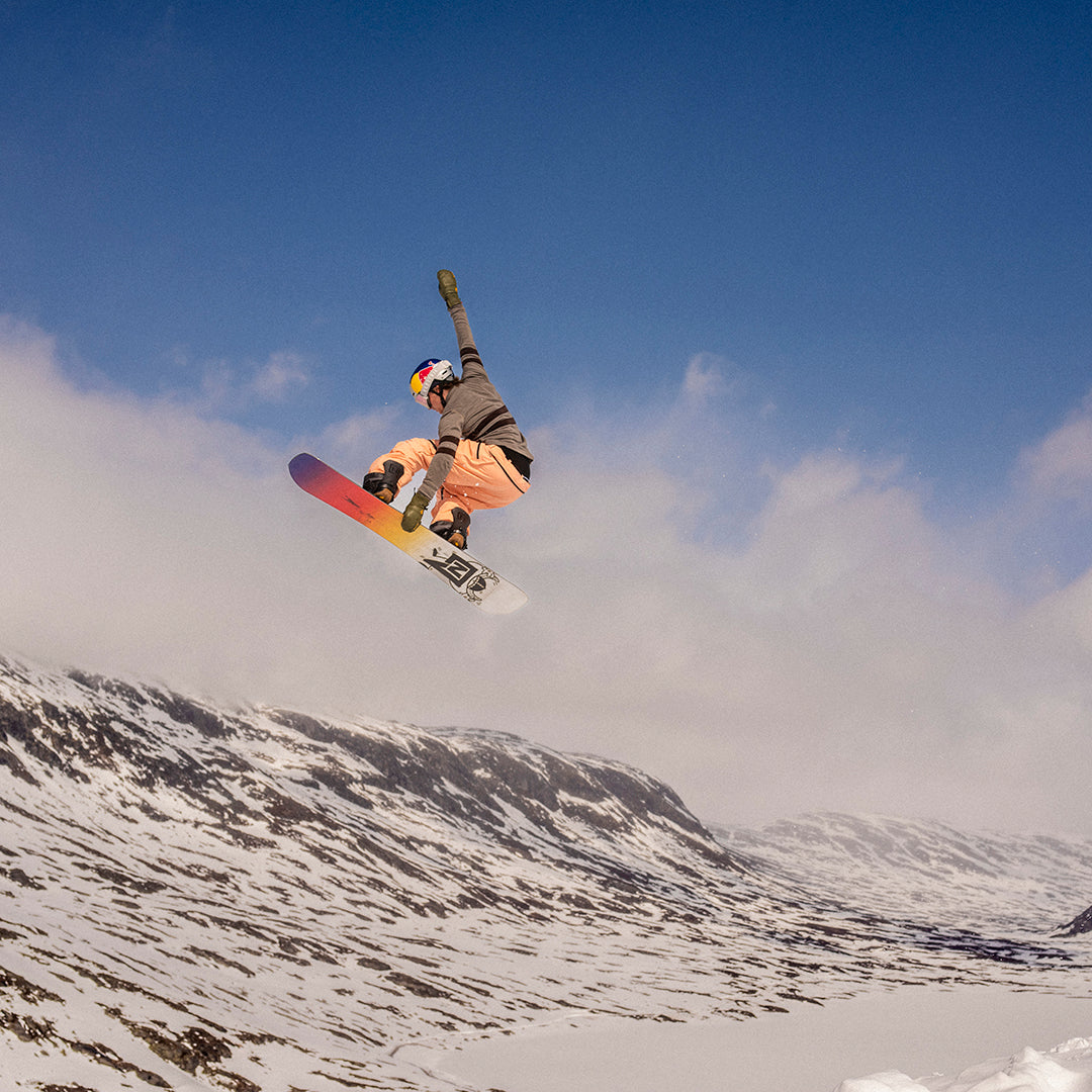 Marcus Kleveland med snøbrett i fjellene, med Janus ullundertøy på