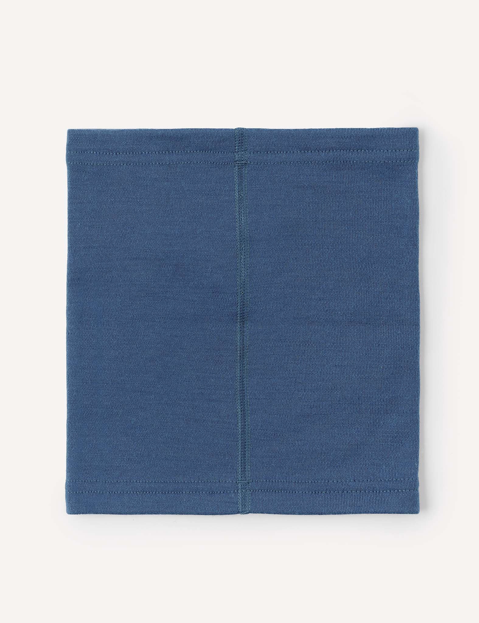 The Neckwarmer – Merino Kids AirWool in blue is laid flat, displaying a visible vertical center seam. The stitching around the edges and its simple rectangular design are clearly shown.
